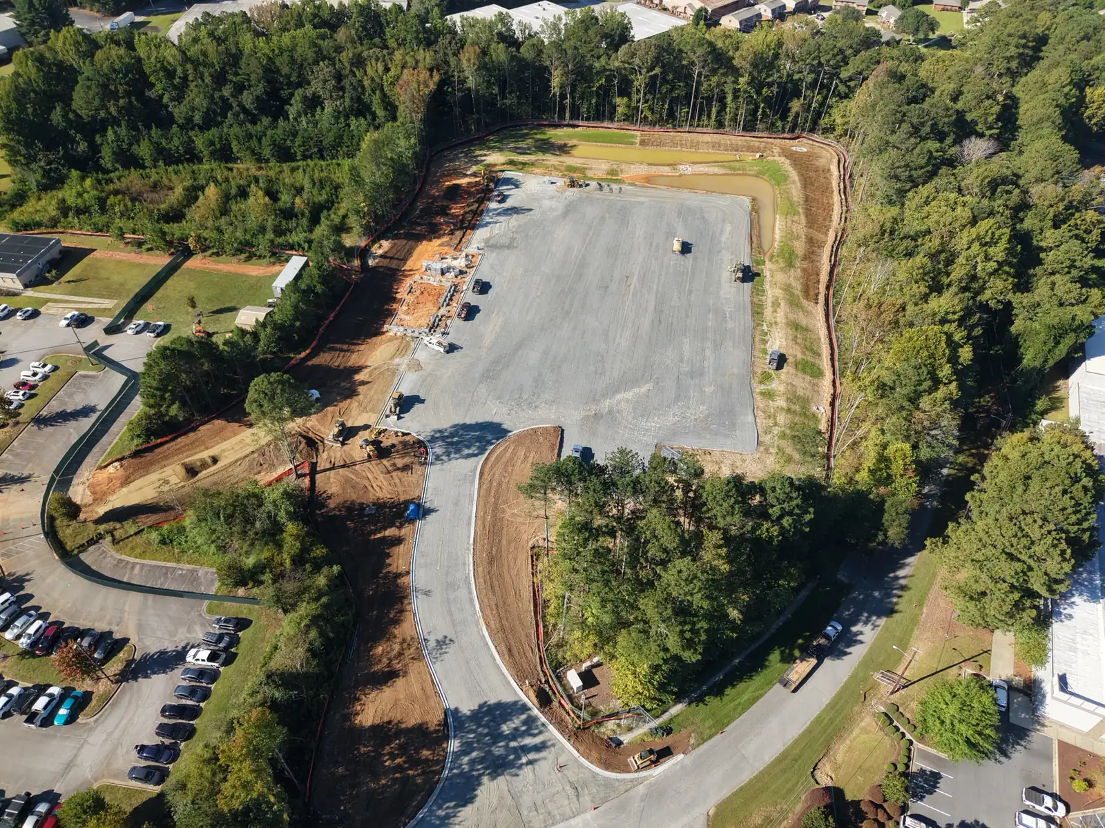 Drone view of the TCSG-411 CDL pad in Dallas, Georgia on September 29, 2026, with stone base, a curbed entrance drive, and building foundation work